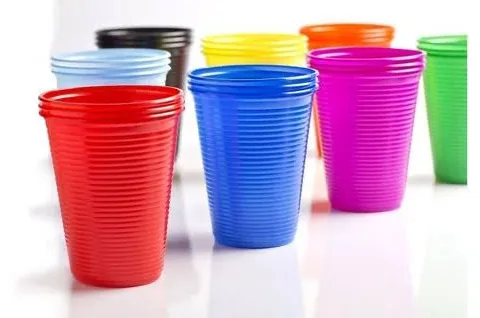 Copos plásticos descartáveis em vermelho, azul, amarelo, rosa, verde, preto e laranja, agrupados sobre fundo branco